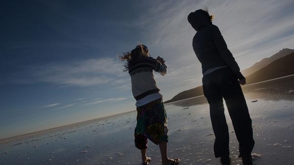 Two women photographing the reflective salt flats in bolivia