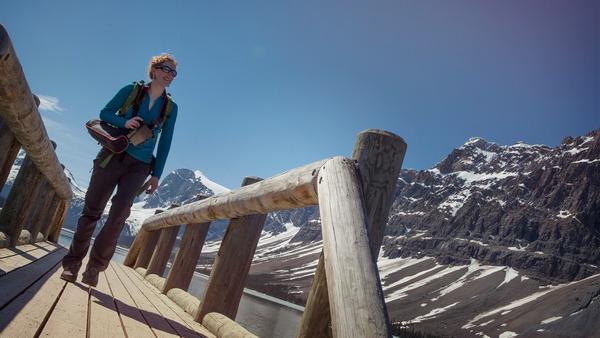 woman crossing a bridge over Lake Louise