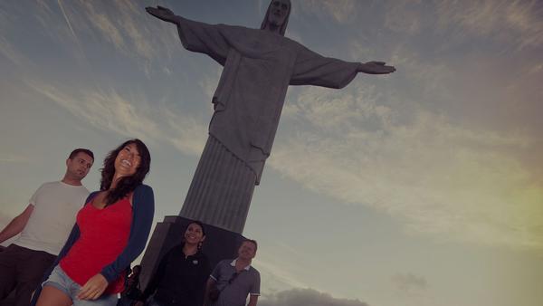 smiling tourists posing with Christ the redeemer in Rio de Janeiro, Brazil