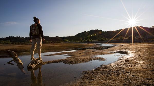 Female travelled looking at a beautiful sunset in Abel Tasman National Park, New Zealand